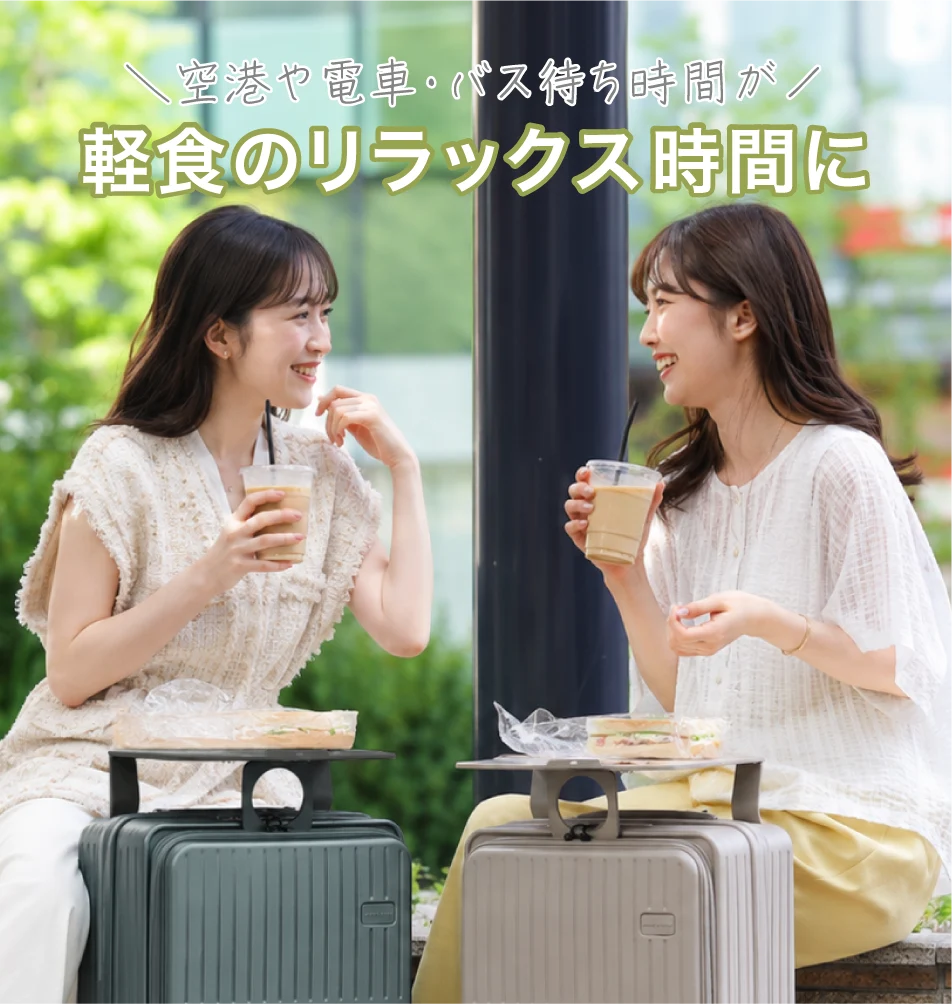 女性2人がスーツケースのテーブルの上にサンドイッチを置いて軽食と談笑を楽しんでいる写真